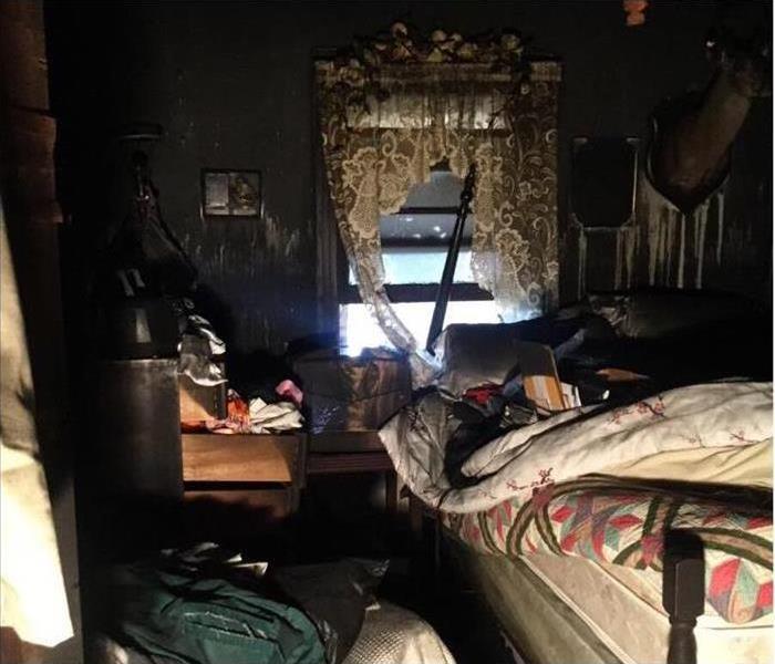 Image of a bedroom with smoke and soot damage after a terrible fire