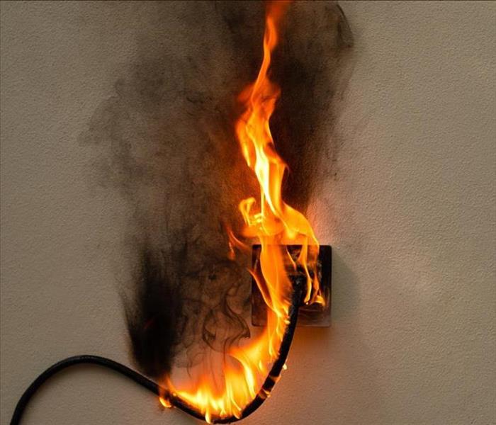 A power cord is seen in flames. 